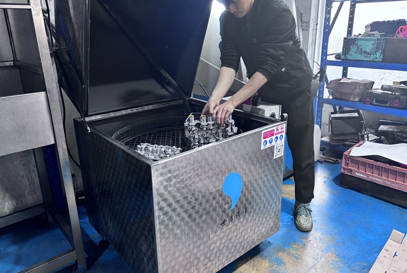 Technician loading valve body components into the ultrasonic cleaning tank