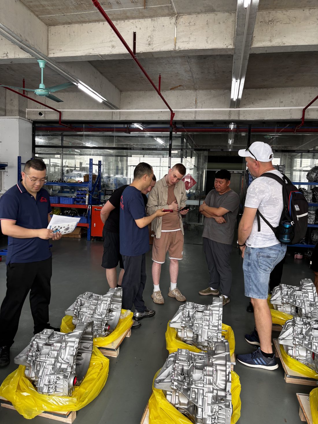 Visiting buyers inspecting finished transmission units on the workshop floor